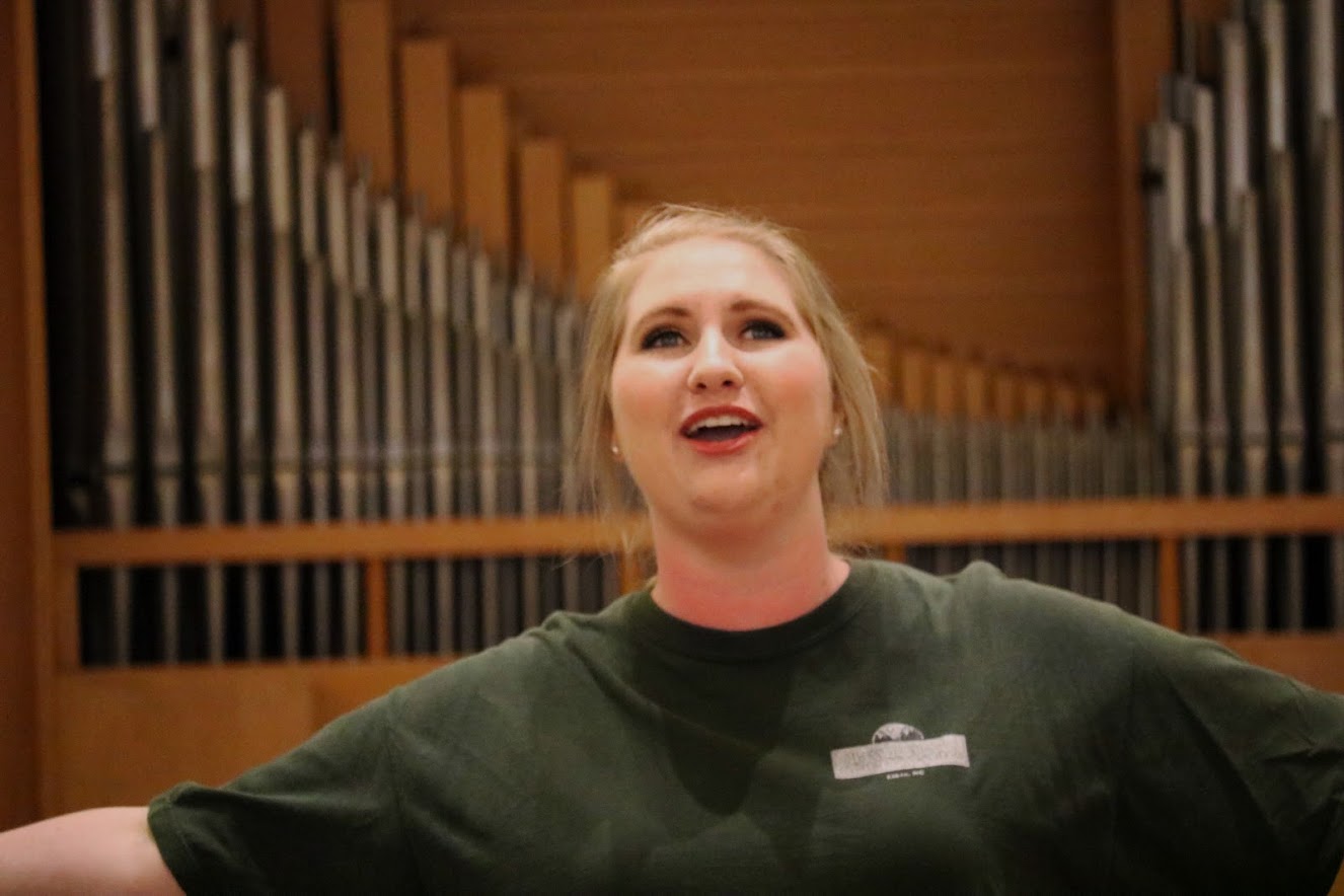 Close up of Aspen Jackson singing with the organ in Person Recital Hall behind her.