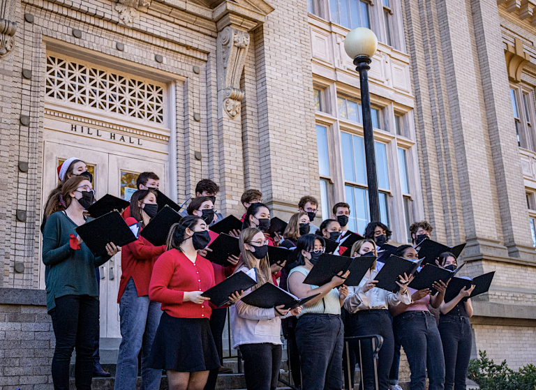 The UNC Chamber Singers stand in formation as they sing carols on the steps of Hill Hall