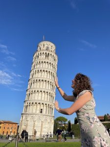 Madi Marks posing as if holding up the leaning tower of Pisa.