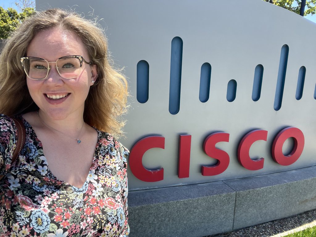 Courtney Hedgecock stands with the sign for Cisco