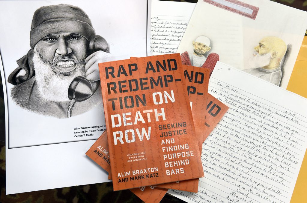 Rap and Redemption book sits on top of written manuscripts and  a drawing Alim Braxton.